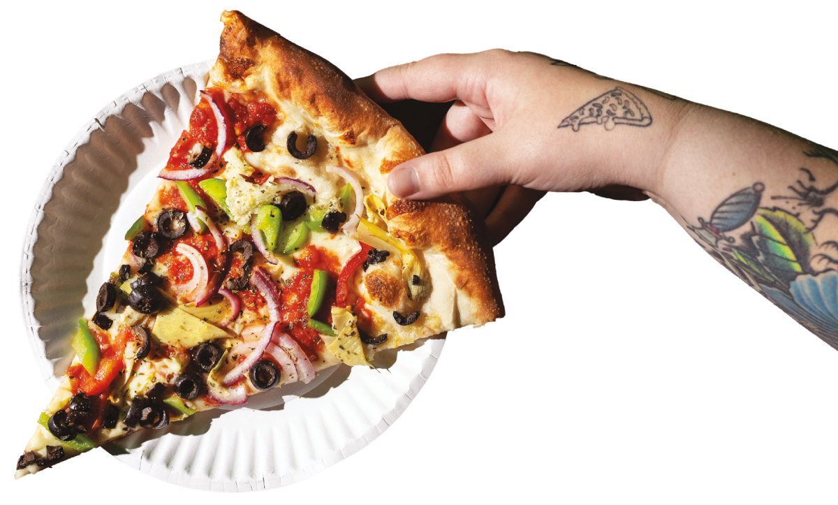 Hand holding supreme slice of pizza