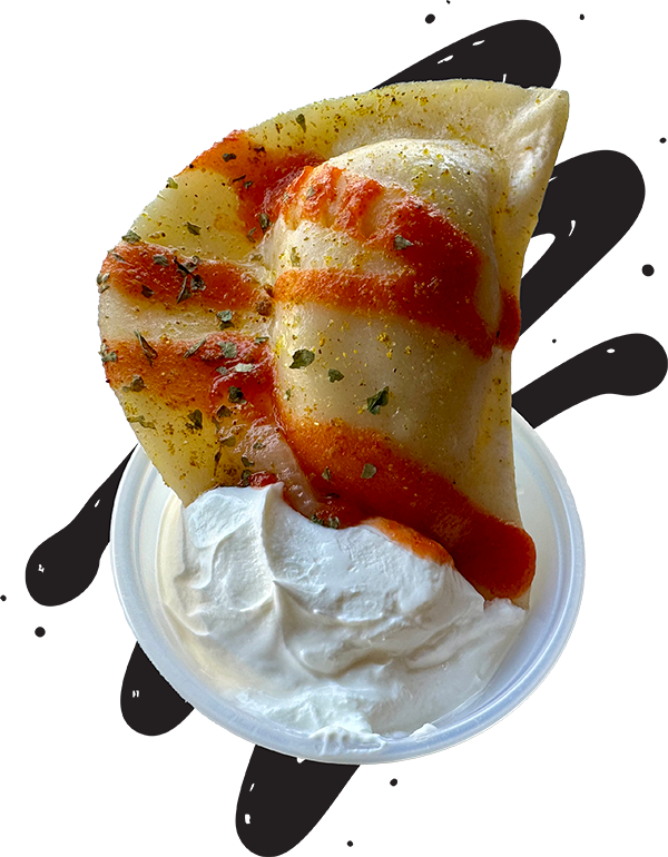 Photo of a stylized pierogi with red sauce being dipped in a dish of sour cream